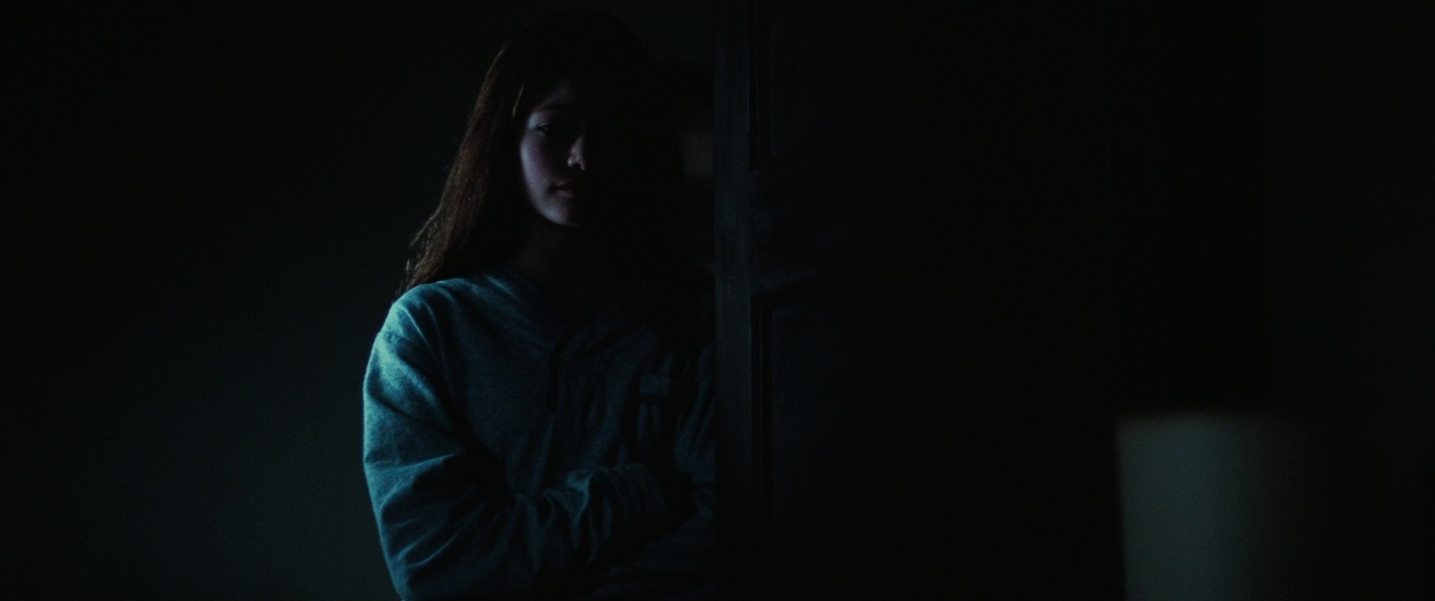 a woman standing in a dark room in the dark