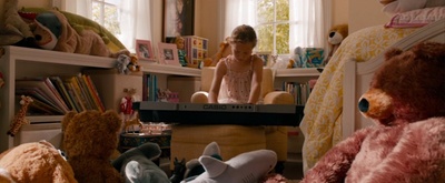 a girl sitting in a room with stuffed animals