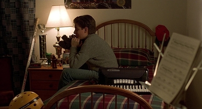 a boy sitting on a bed holding a teddy bear