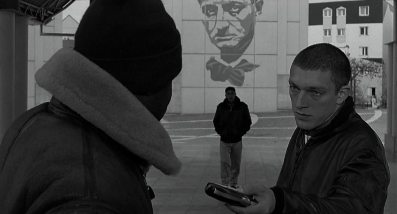 a black and white photo of a man holding a cell phone