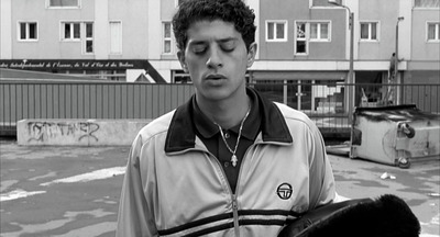 a man standing in a parking lot with his eyes closed