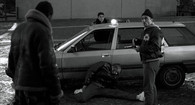 a group of people standing around a parked car