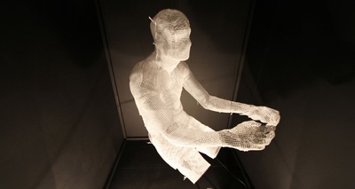 a sculpture of a person sitting in a room