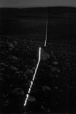 a black and white photo of a long line of lights