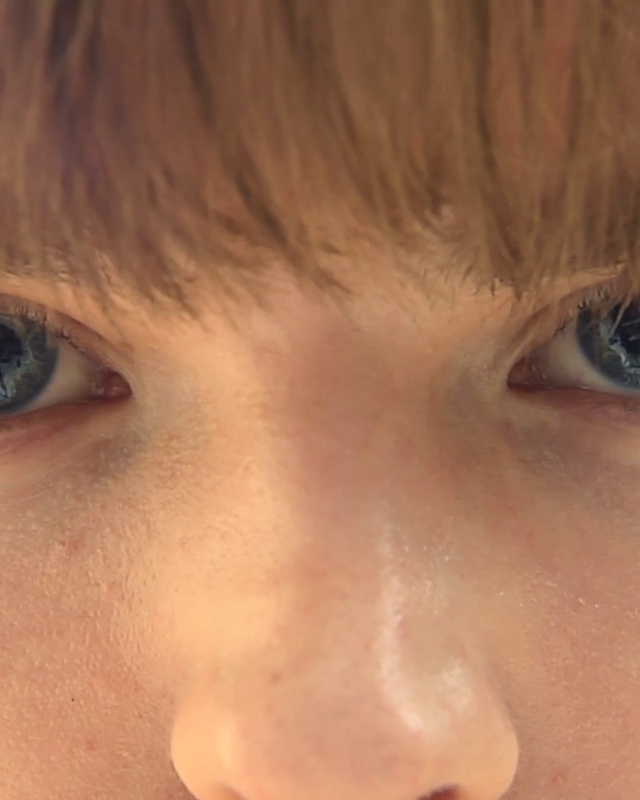 a close up of a person's face with blue eyes