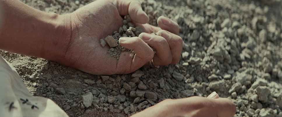 a person holding a handful of dirt in their hand