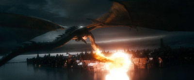 a large dragon flying over a crowd of people