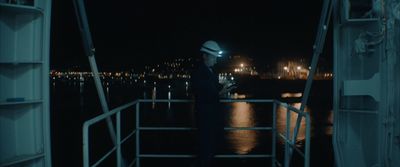 a man standing on a boat at night