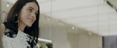 a woman standing in front of a mirror wearing large hoop earrings