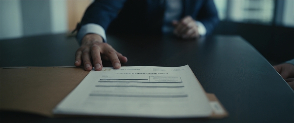 a person sitting at a table holding a piece of paper