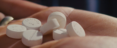 a person holding a bunch of pills in their hand