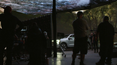 a group of people standing around a white car