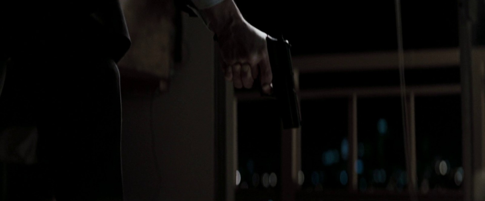 a person holding onto a door handle in the dark