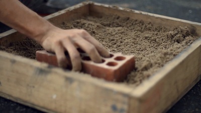 a person putting sand in a wooden box