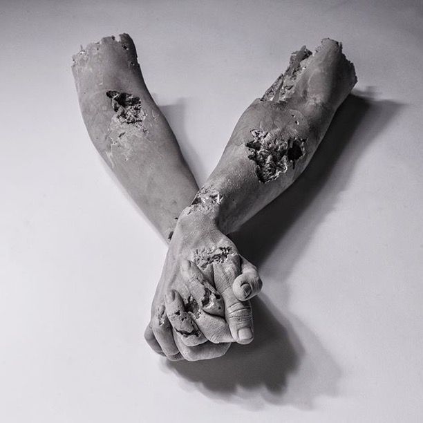 a black and white photo of two hands covered in paint