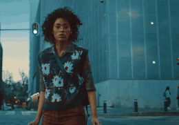 a woman walking down a street holding a suitcase