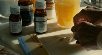 a person is holding a spoon in front of a table full of medicine bottles