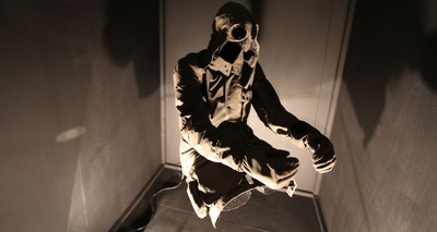 a man in a gas mask is standing in a dark room