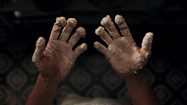 a person covered in powder holding their hands in the air