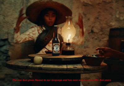 a woman sitting at a table with a bottle of wine