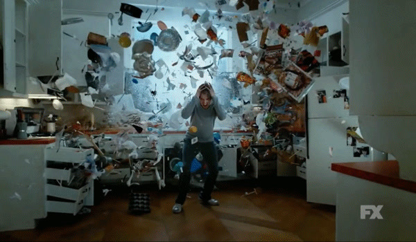 a man is sitting in a messy kitchen