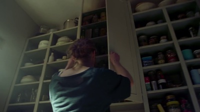 a woman standing in front of a pantry filled with food