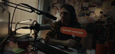 a man sitting at a desk in front of a microphone