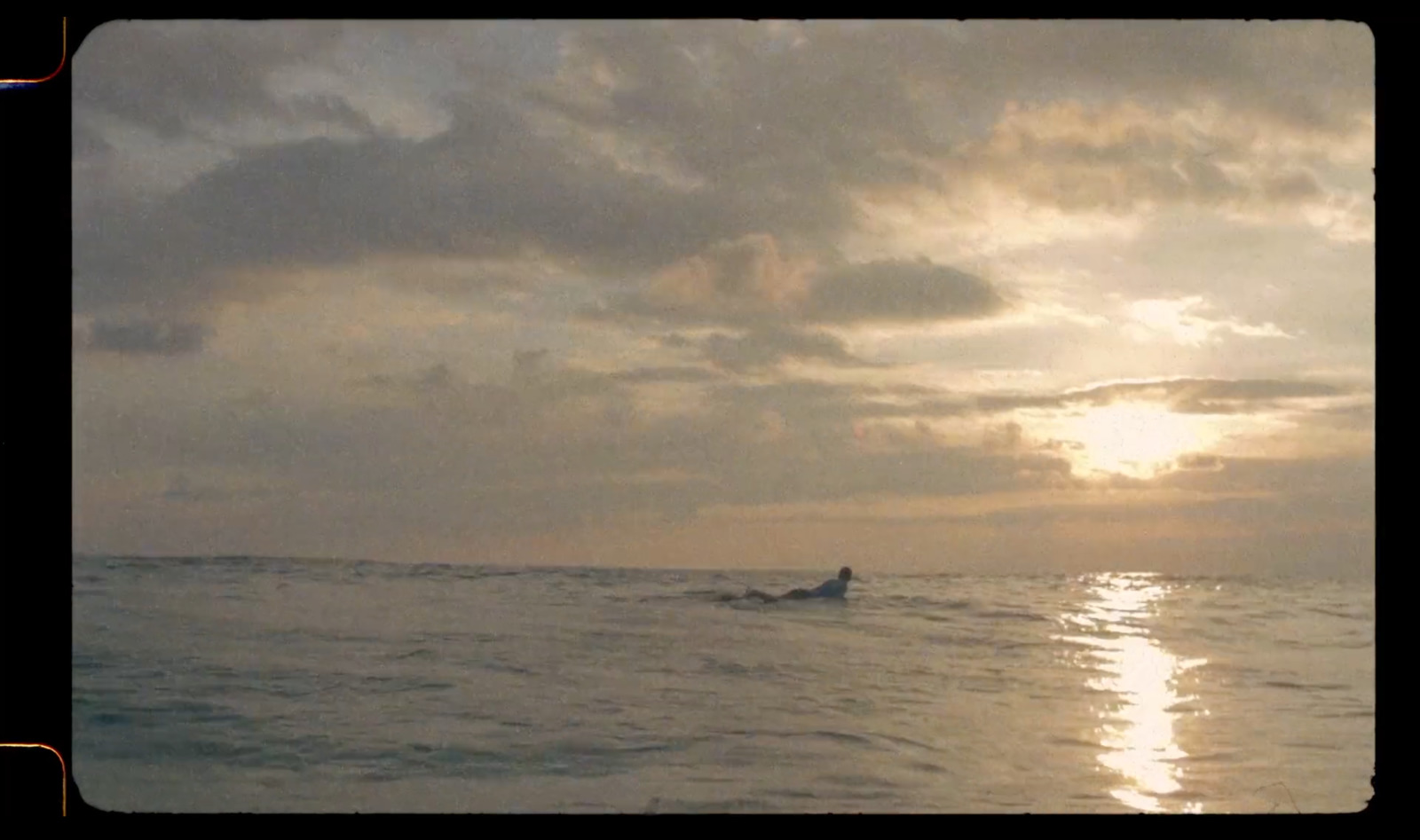 a person riding a surfboard in the ocean at sunset