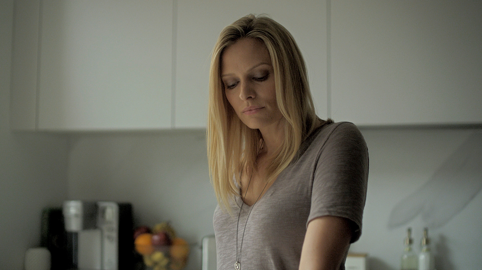 a woman standing in a kitchen preparing food