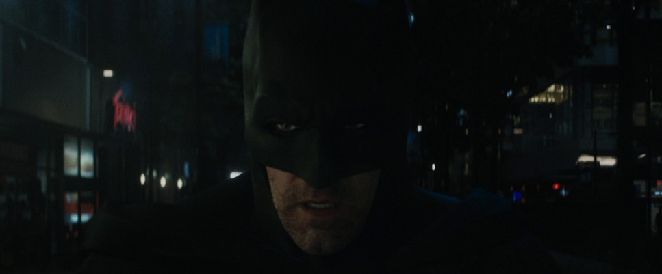 a man in a batman costume standing in the dark