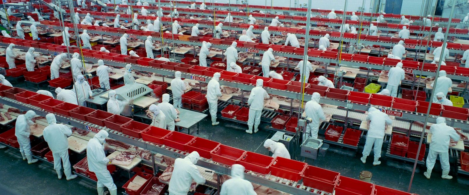 a factory filled with lots of red and white tables