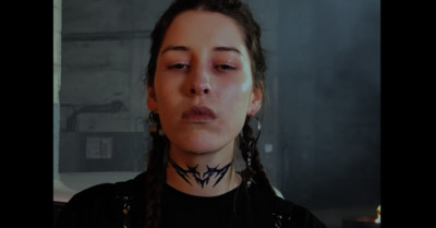 a woman with long braids wearing a black shirt