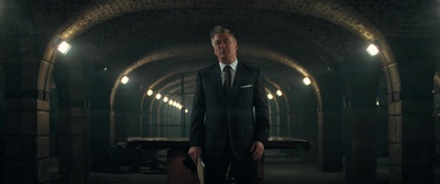 a man in a suit and tie standing in a tunnel