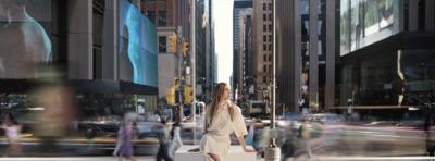 a woman walking across a street in a city