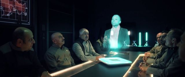 a group of people sitting around a table in a dark room