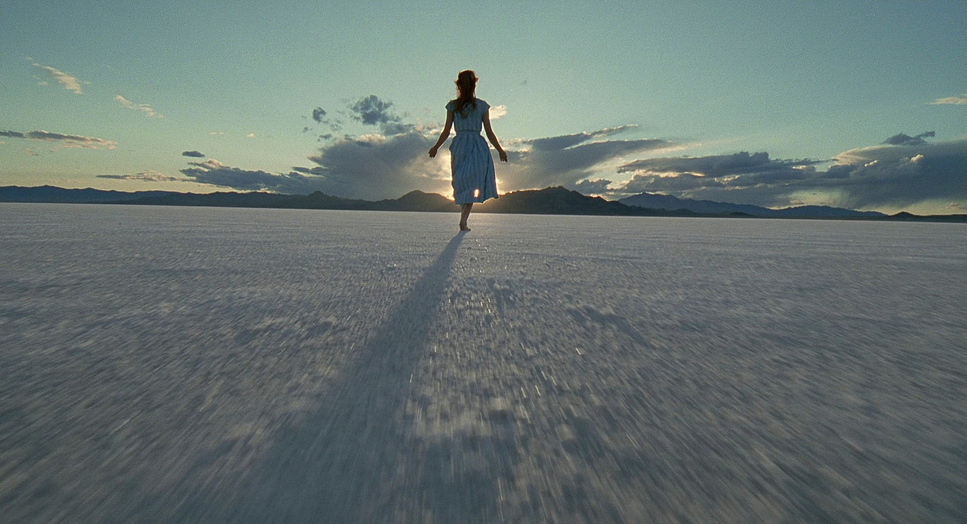 a woman walking across a large open field