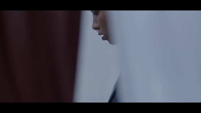 a close up of a person's face with a curtain in the background