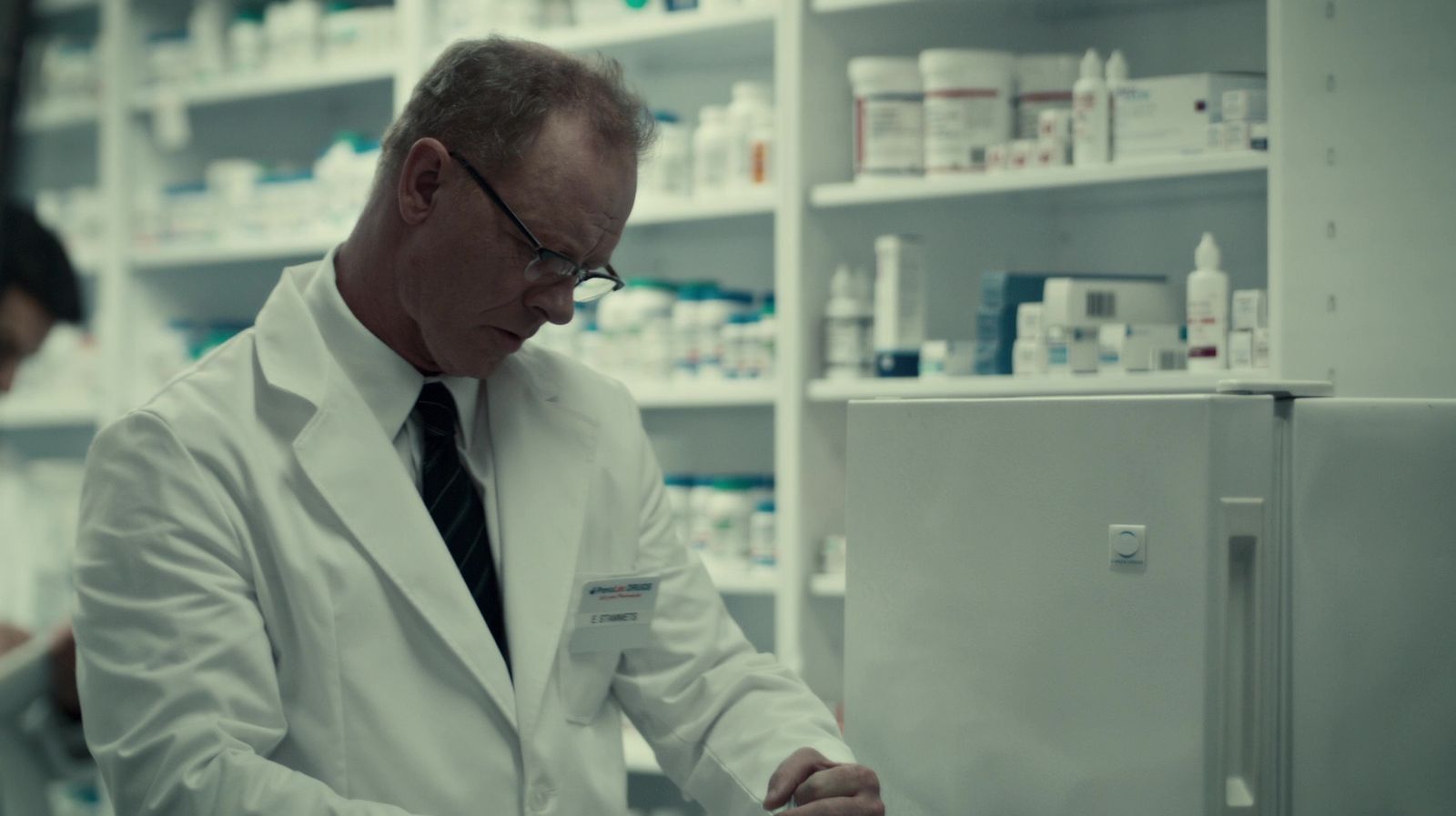 a man in a white lab coat and tie