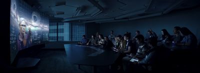 a group of people sitting around a table in a dark room