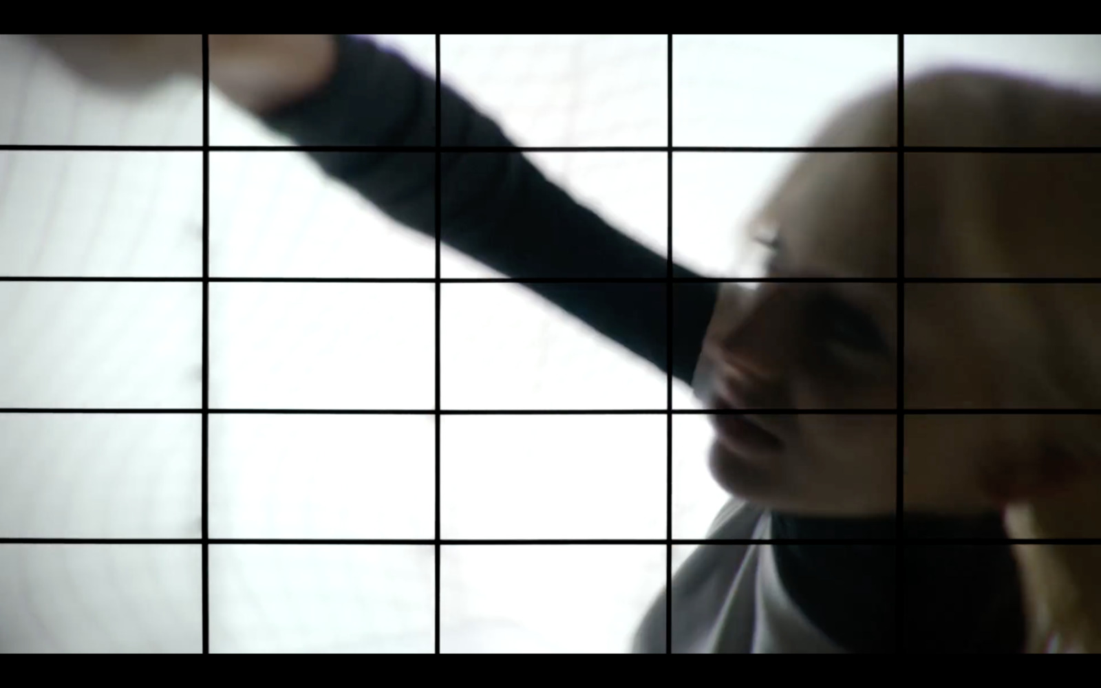 a woman holding her hand out in front of a tiled wall