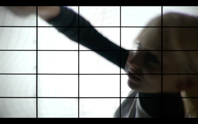 a woman holding her hand out in front of a tiled wall