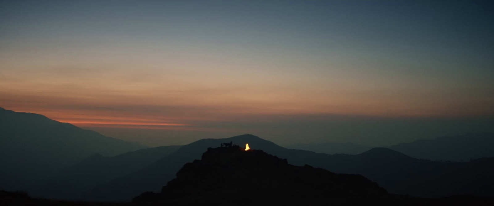 the sun is setting over a mountain range