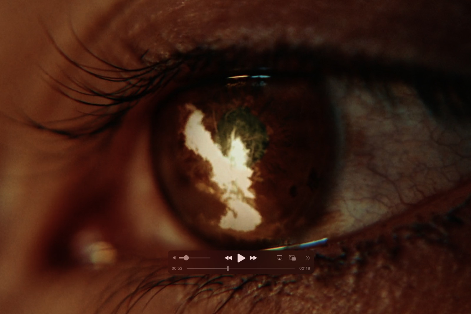 a close up of a person's eye with the reflection of a cloud in