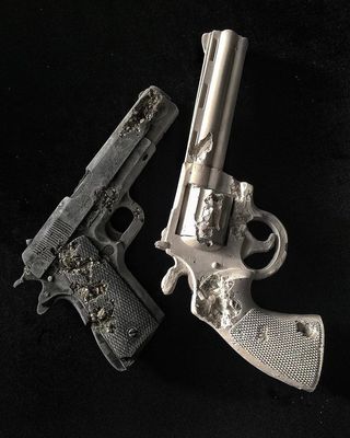 a silver gun and another silver gun on a black background