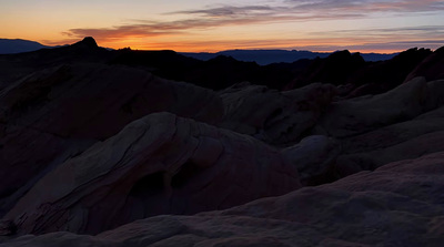 the sun is setting over the mountains in the desert