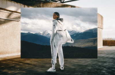 a woman standing in front of a picture of mountains