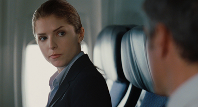 a woman sitting on an airplane looking at a man