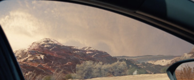 a view of a snow covered mountain from a car window