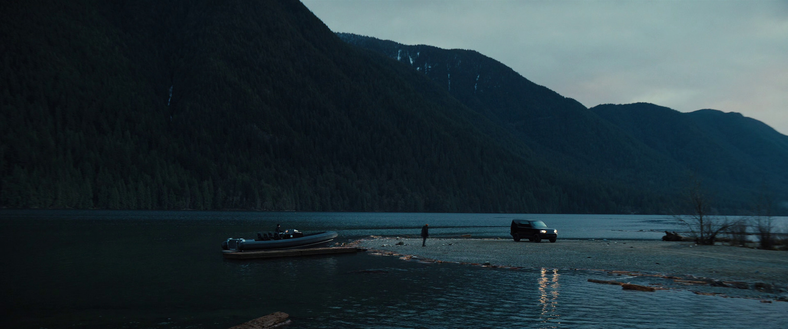 a boat sitting on the shore of a lake