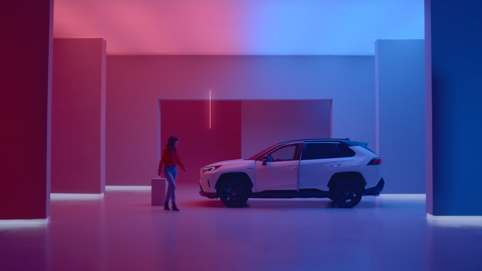 a woman standing next to a car in a room